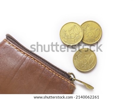 Fifty-cent coins by a leathern purse. European Union coins on white background. EU metal money. 50 Cent Euro Coins Royalty-Free Stock Photo #2140062261