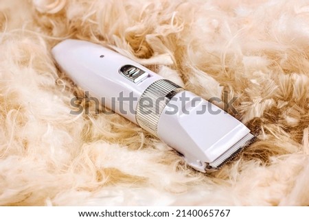 White pet hair trimmer of clipper machine for cat and dog grooming on light cutting fur background Royalty-Free Stock Photo #2140065767