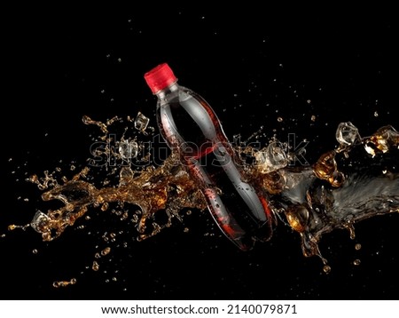 Plastic cola bottle splash with ice cubes on black background Royalty-Free Stock Photo #2140079871