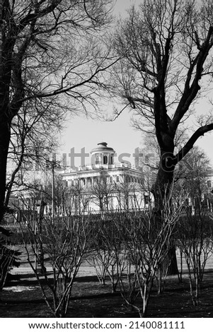 Black and white photography. Dutch angle, view of an old stone building with a turret on the roof.