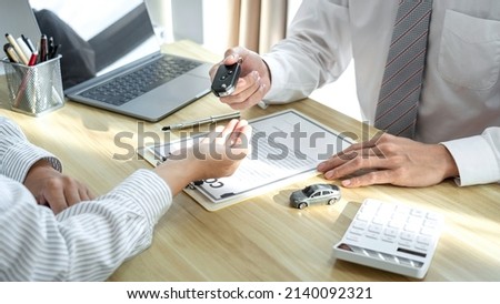 Salesman agent sending a key to customer after the good deal agreement, successful car loan insurance contract buying or selling new vehicle. Royalty-Free Stock Photo #2140092321