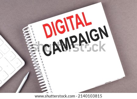 DIGITAL CAMPAIGN text on a notebook with calculator and pen,business concept