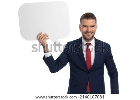 handsome businessman presenting a speech bubble with a smile on his face, against white background