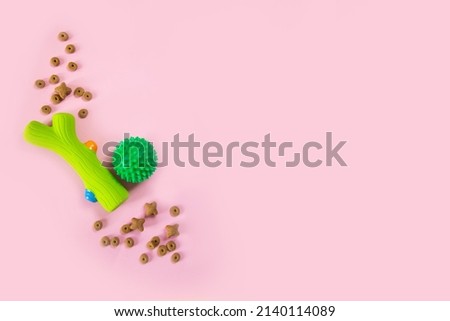Simple flat lay with ball toy and food on pink background. pet accessories. View from above. Pet care and animals concept. Top view copy space banner