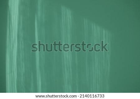 Abstract turquoise background. Window sunlight reflecting on a modern green wall. 