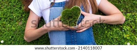 girl with heart-shaped bowl with grass. love nature ecology concept
