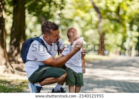 Father helping son to blow a nose because of spring allergies. Royalty-Free Stock Photo #2140121955