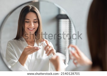 Beauty Routine. Attractive Young Female Applying Makeup Removal Milk On Cotton Pad While Standing Near Mirror In Bathroom, Smiling Beautiful Lady Cleansing Skin, Making Daily Skincare At Home Royalty-Free Stock Photo #2140128701