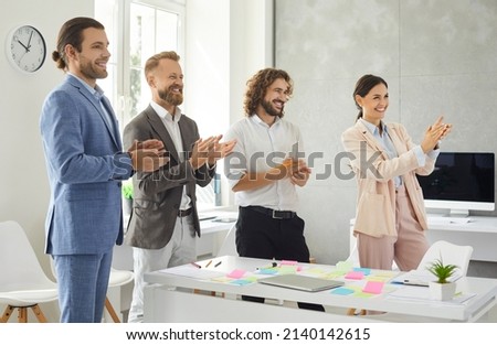 Overjoyed millennial diverse businesspeople applaud clap hands greet colleague with promotion or job success. Smiling multiracial employees congratulate presenter speaker. Acknowledgement concept. Royalty-Free Stock Photo #2140142615