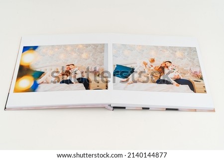 a book with photos of big family at home on a white background. Photobook is gift. professional photographer and designer. printing of photos and journals in photo laboratory Royalty-Free Stock Photo #2140144877