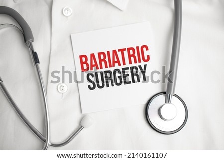 Grey stethoscope and paper plate with a sheet of white paper with text bariatric surgery light blue backround. Medical concept. Royalty-Free Stock Photo #2140161107