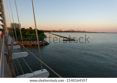 View of downtown Toronto skyline from Humber Bay Arch Bridge during a summer evening.