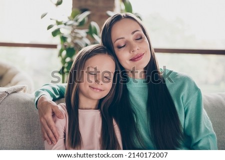 Photo of family bonding harmony concept lady cuddle small girl close eyes wear casual outfit in comfortable home indoors