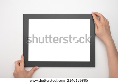 Holding frame mockup. Photo Mockup. Woman hands hold black frame. For frames and posters design. Frame size A4. isolated on white background. blank photo frame border with copy space in hands close up