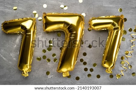 Lucky number seven on a concrete background. yellow balloons three sevens. Close-up Royalty-Free Stock Photo #2140193007