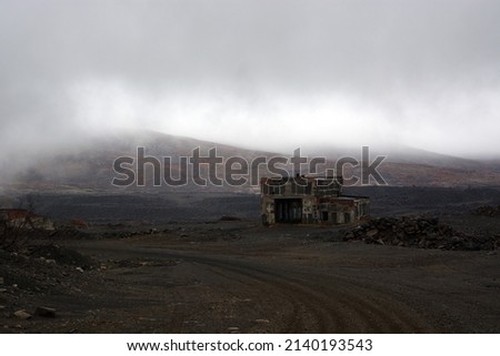 Beautiful mountain scenery in the fog. Old abandoned huge coal pit. Ruins and huge mountains of dirty rock.
