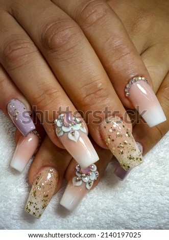 Sparkly sculptured acrylic nail art with gel polish and precious rhinestones Royalty-Free Stock Photo #2140197025