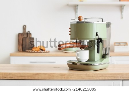 Modern coffee machine with cup on counter in kitchen Royalty-Free Stock Photo #2140215085