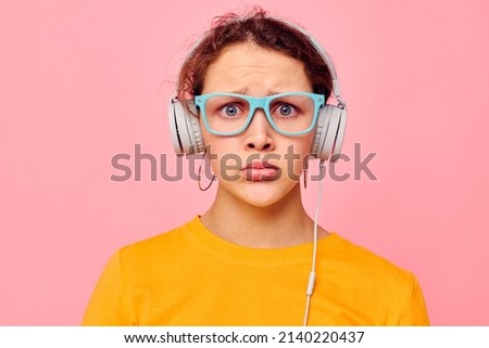 portrait of a young woman wearing headphones blue glasses close-up emotions cropped view unaltered