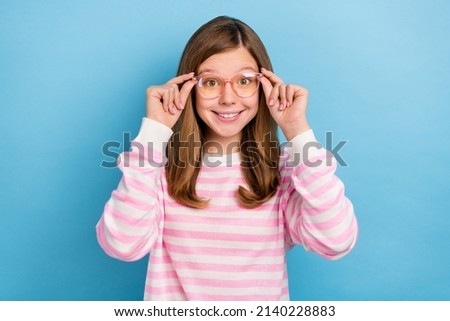 Portrait of satisfied friendly girl hands touch glasses toothy smile look camera isolated on blue color background