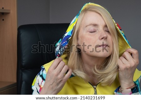 Woman in colorful clothes daydreaming in the office