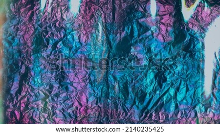 Crumpled holographic foil texture. Shiny glitter purple blue background