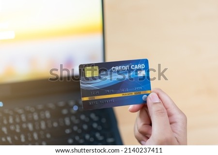 Customer using credit card for online shopping. Purchase something using credit card and in put via laptop.