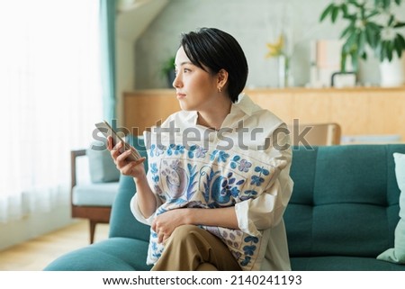 Woman looking at smartphone in living room