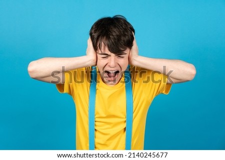 Teenager boy screaming hands on ears. Puberty confusion and anxiety concept Royalty-Free Stock Photo #2140245677