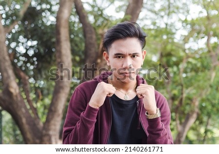 A young furious guy in a fight. Showing his fists as a sign getting ready for a fight.