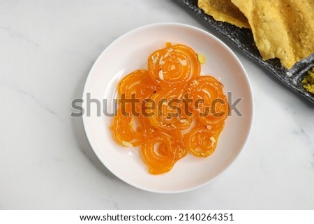 Popular Indian sweet Jalebi and Fafda served with Sambhara. Gujarati snack is mostly eaten during Indian Festivals such as, Gudi Padwa, Dussehra, Eid, Diwali, Mahashivratri, Holi. with Copy space.  Royalty-Free Stock Photo #2140264351
