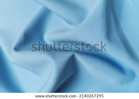 Blue crumpled or wavy fabric texture background. Abstract linen cloth soft waves. Silk atlas or stretch jacquard. Smooth elegant luxury cloth texture. Concept for banner or advertisement.