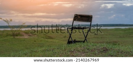 Camping chairs on a field against a dark sky background.