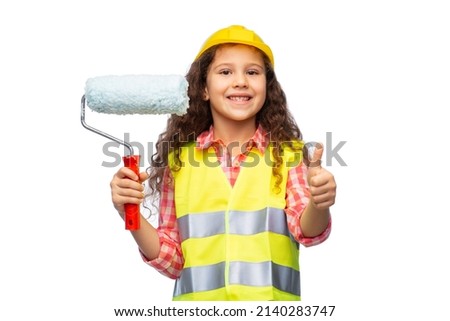 building, construction and profession concept - smiling little girl in protective helmet and safety vest with paint roller showing thumbs up over white background