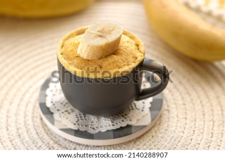 selective focus. cupcake in a mug with banana pieces. Banana cupcake on a light background. vanilla biscuit in a mug. The concept of a dessert in the microwave. bananas cake. High quality photo Royalty-Free Stock Photo #2140288907