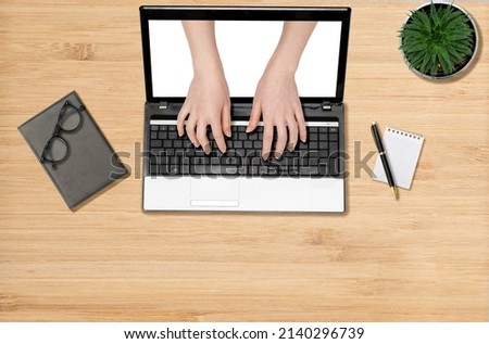 Women's hands are typing on a laptop, appearing from a computer screen. Mock up. Flat lay. The concept of online education and business.