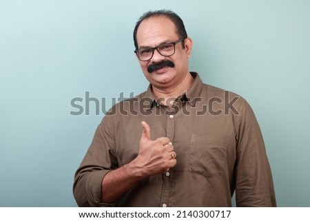 Portrait of a middle aged man of Indian ethnicity shows Ok gesture Royalty-Free Stock Photo #2140300717