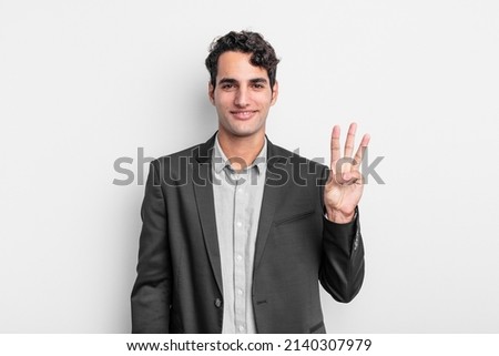 young businessman smiling and looking friendly, showing number three or third with hand forward, counting down