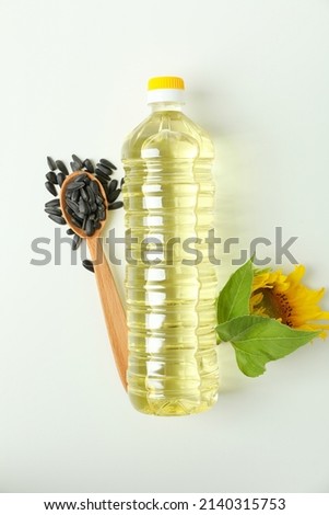 Bottle of sunflower oil and ingredients on white background
