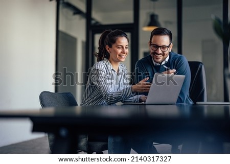 Smiling business people, looking at something over the laptop. Royalty-Free Stock Photo #2140317327