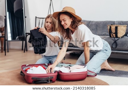 Mother and daughter going on trip pack suitcase Royalty-Free Stock Photo #2140318085
