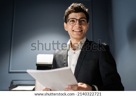 The manager is a man with glasses in formal clothes working in a coworking space, Holding documents on paper.