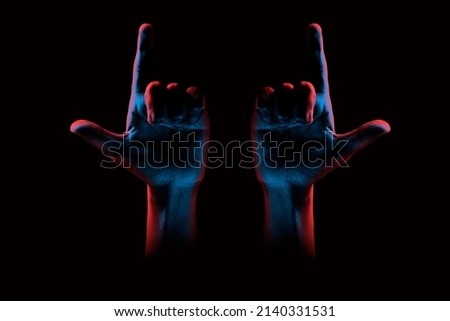 Hands showing looser sign on dark background