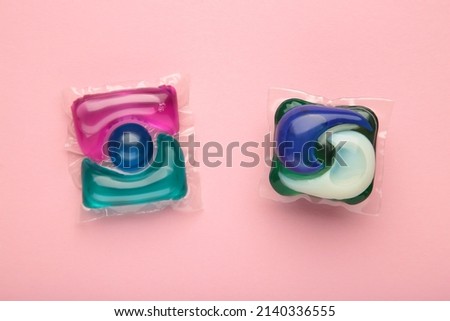 Washing powder in capsules on a pink background. Top view.