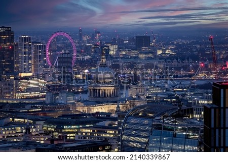 Elevated, panoramic view of the illuminated skyline of London with St. Pauls Cathedral and Westminster district