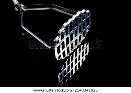stainless steel potato masher against a black background Royalty-Free Stock Photo #2140341825