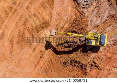 Digger on earthworks in excavator dig the trenche at construction site on arial view of the laying sewer pipes