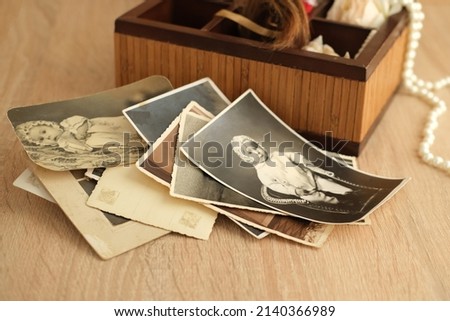 dear to heart memorabilia in an old wooden box, stack of retro photos, vintage photographs of 1940, concept of family tree, genealogy, childhood memories, home archive Royalty-Free Stock Photo #2140366989