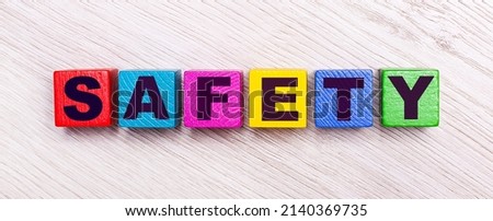 On a light wooden background, multi-colored wooden cubes with the text SAFETY