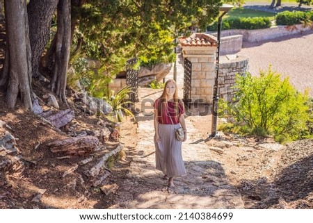 Woman tourist walking together in Montenegro. Panoramic summer landscape of the beautiful green Royal park Milocer on the shore of the the Adriatic Sea, Montenegro